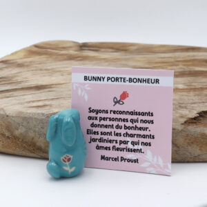 Lapin turquoise en céramique dans une boite en carton accompagné d'une citation